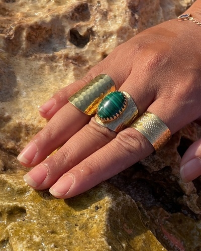 Photo d'une main avec une bague sertie d'une pierre verte