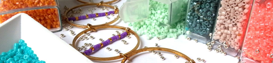 Photo d'un bijoux comportant des perles Miyuki devant des boîtes transparentes remplies de perles.